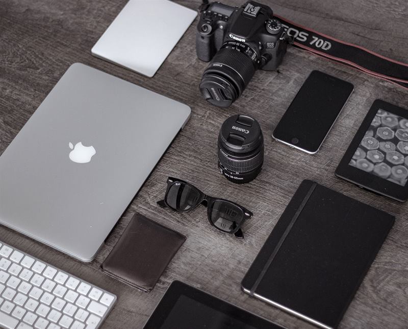 A closer view of the workshop desk with a laptop, camera, and notebook.